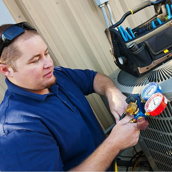 A qualified technician from Legend Air performs a maintenance check on a customer's air conditioner